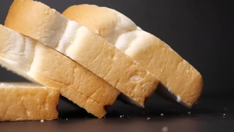Bread slice falling in slow motion on black table Stock Footage 142914920