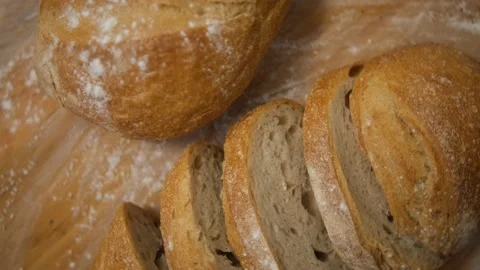 Bread sliced and freshly baked on a wooden table. Flour, bakery. The cooking pro Stock Footage 148602512