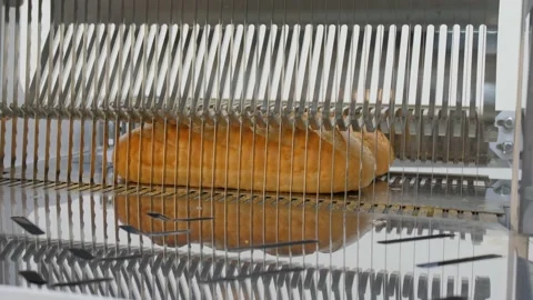 Bread slicer in factory. Sharp knives cuts bread Stock Footage 131822936
