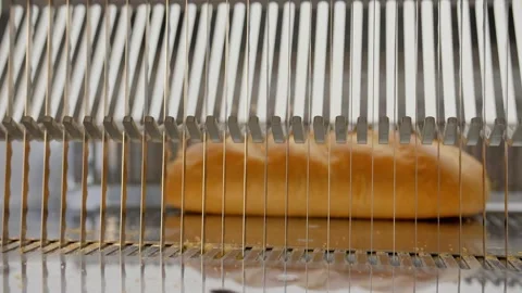 Bread slicer in factory. Sharp knives cuts bread in slow motion Stock Footage 131823483