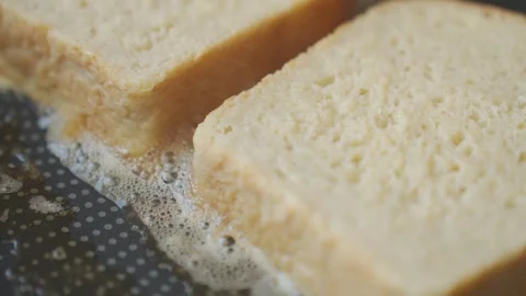 Bread slices cook on frying pan. Concept of French toast Stock Footage 337434082
