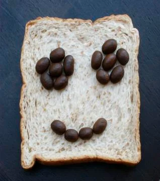 Bread slices with face of coffee beans Stock Photos