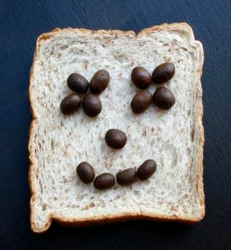 Bread slices with face of coffee beans Stock Photos