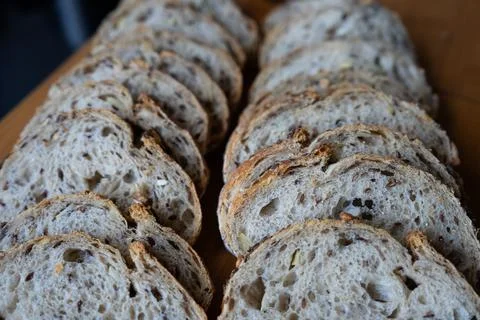 Bread slices lined up on wooden table Stock Photos