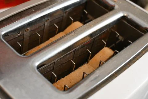 Bread slices in a metal toaster 库存照片