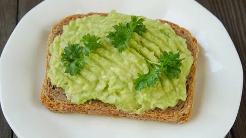 Bread spread with avocado on a plate. Stock Footage 248081753