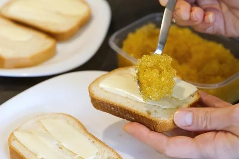 Bread spread with salted pike caviar. Stock Photos