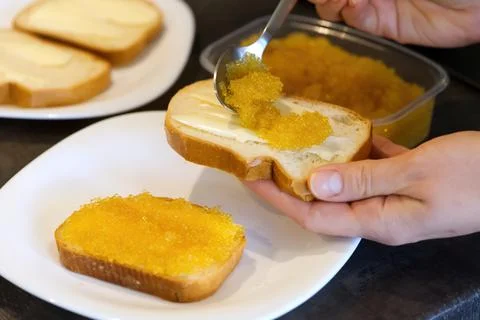 Bread spread with salted pike caviar. Stock Photos