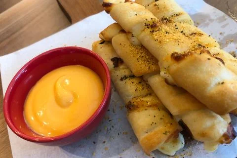 Bread stick with dip cheeses on a board in restaurant Stock Photos
