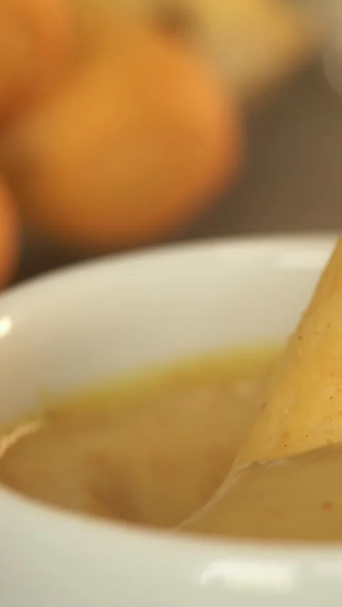 Bread stick is dipped in mustard sauce. Crouton. Food. Bread. Stock Footage 302284950