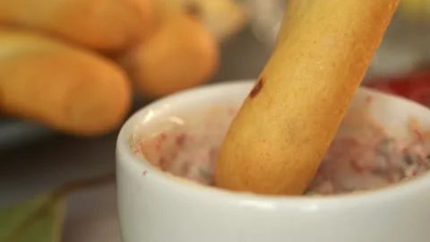 Bread stick dips in mayonnaise sauce with greens and spices. Toast crouton snack Stock Footage 165538043