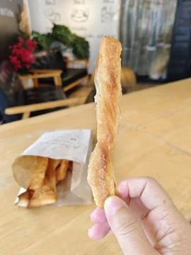 A bread stick in hand. Stock Photos