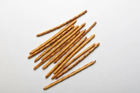 Bread sticks scattered on a white background, crispy snack with poppy seeds Stock Photos