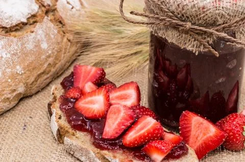 Bread with strawberry jam (rustic background) Stock Photos