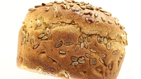 Bread with sunflower seeds, lying on its side rotates clockwise, turning Stock Footage 148878672