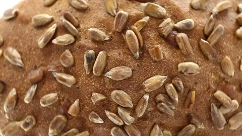 Bread with sunflower seeds, rotates counterclockwise, turning, top view Stock Footage 148878309