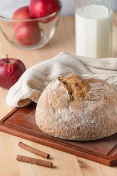 Bread on a table made of wood. Red apples and milk jug. 스톡 사진