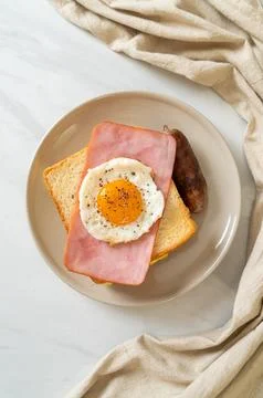Bread toasted cheese topped ham and fried egg with pork sausage Stock Photos