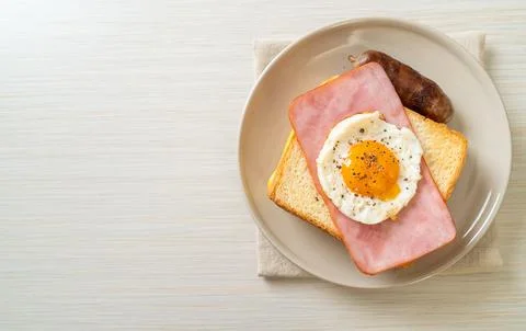 Bread toasted cheese topped ham and fried egg with pork sausage 스톡 사진