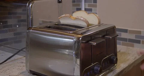 Bread into the toaster in the kitchen at home Stock Footage 120594333