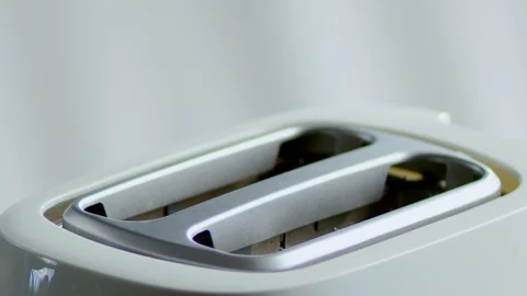 Bread toasts in a white toaster for morning breakfast , cooking in slow motion Video stock 121855342