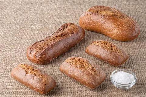 Bread, traditional sourdough bread, on a background of burlap Stock Photos