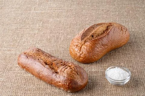 Bread, traditional sourdough bread, on a background of burlap Stock Photos
