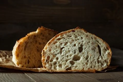 Bread, traditional sourdough bread cut into slices on a rustic wooden backgro Stock Photos