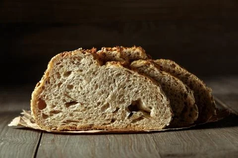 Bread, traditional sourdough bread cut into slices on a rustic wooden backgro Stock Photos
