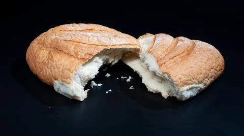 Bread from two halves on a black background . Stock Photos