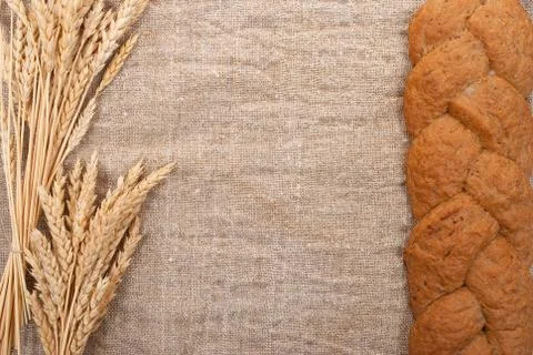 Bread with wheat  ears  on burlap background Stock Photos