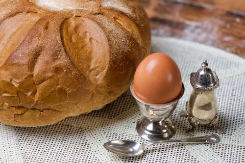Bread on the wooden table with flour, egg in silver vintage utensil, salt shaker Stock Photos