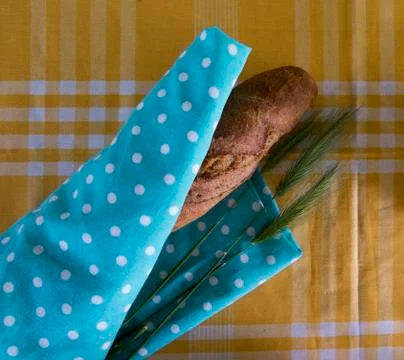 Bread on a yellow tablecloth on a blue substrate Stock Photos