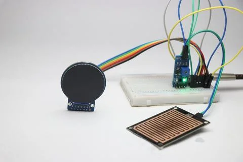 Breadboard circuit connected to raindrop sensor module and the round LCD Stock Photos