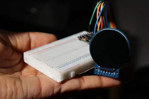 Breadboard connected to microcontroller with jumper cables to round lcd Foto stock
