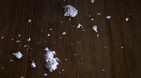 Breadcrumbs falling on to wooden table, close shot 動画素材 46023557