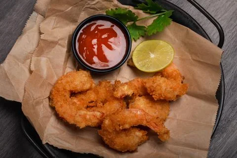 Breaded and breaded shrimp with chilli sauce on black background Stock Photos