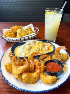 Breaded and Fried Fish with their Tales and Sides of Lobster Sauce Potatoes a Stock Photos