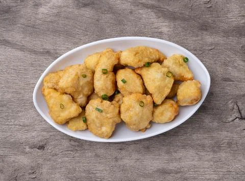 Breaded chicken bites in a plate over wooden table Stock Photos