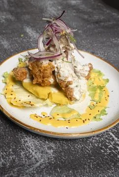 Breaded chicken breast resting on mashed potatoes with lettuce, red onions .. Stock Photos