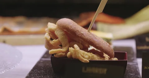 Breaded chicken burger with potatoes on a table in a Madrid restaurant in Stock Footage 291008631