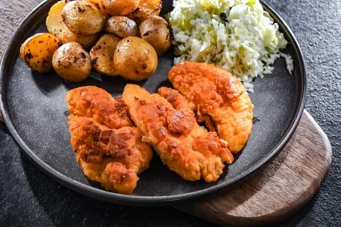 Breaded chicken cutlets served with potatoes and cabbage. Stock Photos