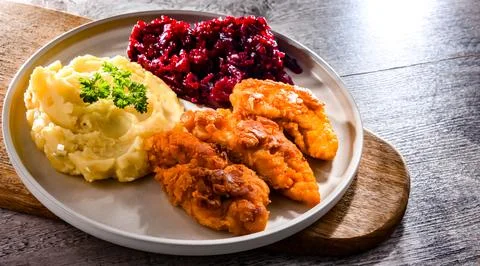 Breaded chicken cutlets served with potatoes and beetroot Foto stock