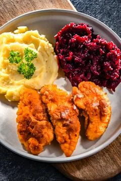 Breaded chicken cutlets served with potatoes and beetroot Stock Photos