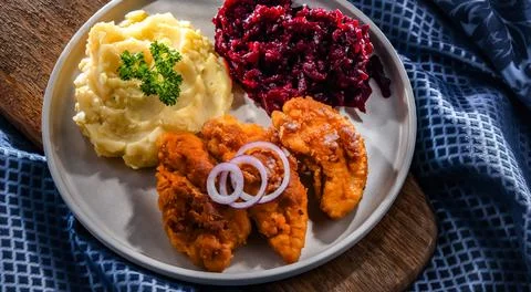 Breaded chicken cutlets served with potatoes and beetroot Foto stock