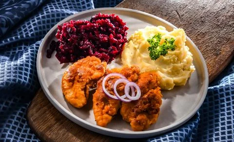 Breaded chicken cutlets served with potatoes and beetroot Foto stock