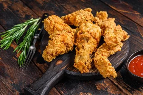 Breaded chicken drumstick, leg, wing and breast tenders strips. Dark Wooden Stock Photos
