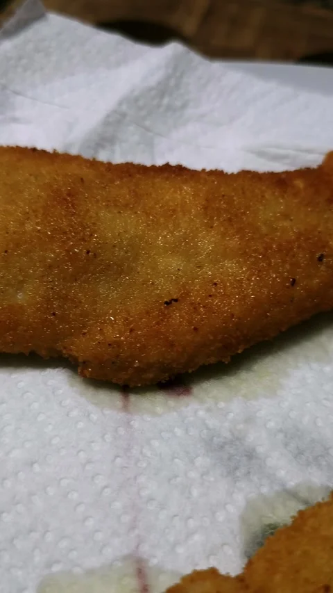 Breaded chicken fillets resting on absorbent paper. Stock Footage 344857989