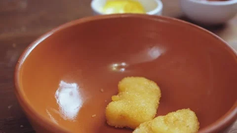 Breaded chicken nuggets fall into the pottery from above Stock Footage 170450956
