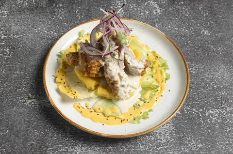 Breaded chicken strips covering mashed potatoes with lettuce, red onions an.. Stock Photos